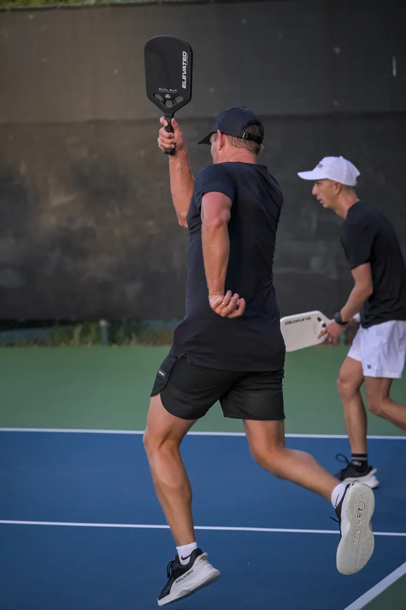 Black paddle in a doubles rally